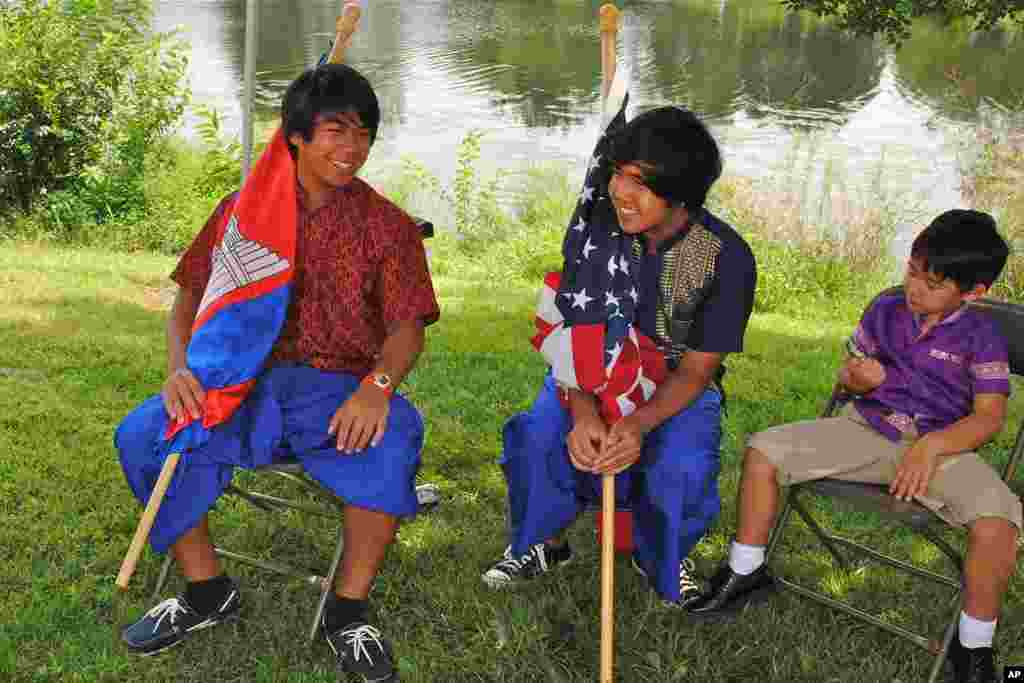 Seaton Sok, 18, and Brendon Holl, 16, proudly carry the Cambodian and American national flags prior to the salutation of both countries' anthems.