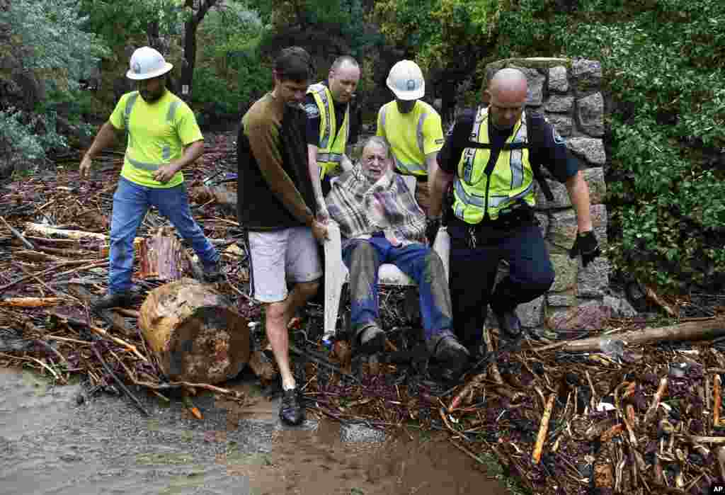 Will Pitner is rescued by emergency workers and neighbor Jeff Writer after a night trapped outside on high ground above his home as it filled with water after days of record rain and flooding at the base of Boulder Canyon, Colorado, Sept. 13, 2013.