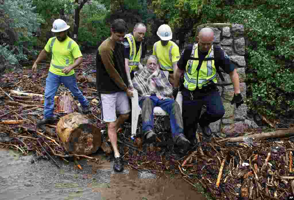 Seorang warga diselamatkan petugas setelah terjebak semalaman di dataran tinggi di atas rumahnya yang terendam air, setelah hujan besar berhari-hari dan banjir di Ngarai Boulder, Colorado (13/9).