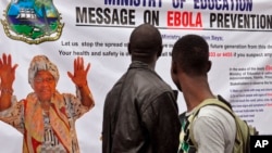 The image of Liberia President Ellen Johnson Sirleaf, left, appears on a public information banner warning people about the Ebola virus in the city of Monrovia, Aug. 8, 2014.
