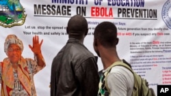FILE - Liberian President Ellen Johnson Sirleaf appears on a banner warning people about the Ebola virus in Monrovia, Aug. 8, 2014.