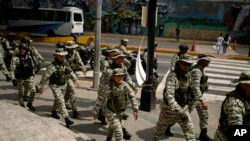 Miembros de la Milicia Bolivariana caminan por una calle durante ejercicios militares en Caracas, Venezuela, el jueves 23 de enero de 2025. (Foto AP/Ariana Cubillos)