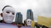 Para wartawan Indonesia mengenakan topeng saat mengikut pawai Hari Buruh di Museum Nasional (Monas), Jakarta, 1 Mei 2019. (Foto: Reuters)