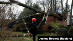 Un trabajador corta un árbol que cayó sobre una casa durante el paso de una tormenta con poderosas ráfagas de viento por Kensington, Maryland, Estados Unidos. 2 de marzo, 2018. REUTERS/Joshua Roberts