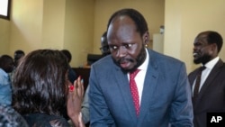 Prominent South Sudanese activist and economist Peter Biar Ajak talks to his wife Nyathon Hoth Mai, left, after he was sentenced to two years in prison, in a courtroom in the capital Juba, South Sudan, June 11, 2019.