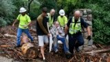 Will Pitner is rescued by emergency workers and neighbor Jeff Writer after a night trapped outside on high ground above his home as it filled with water after days of record rain and flooding at the base of Boulder Canyon, Colorado, Sept. 13, 2013.