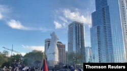 Protesters surround a statue of Christopher Columbus at Grant Park in Chicago, Illinois, U.S., July 17, 2020, in this still image from video obtained via social media. (Madeleine Dupre via REUTERS)