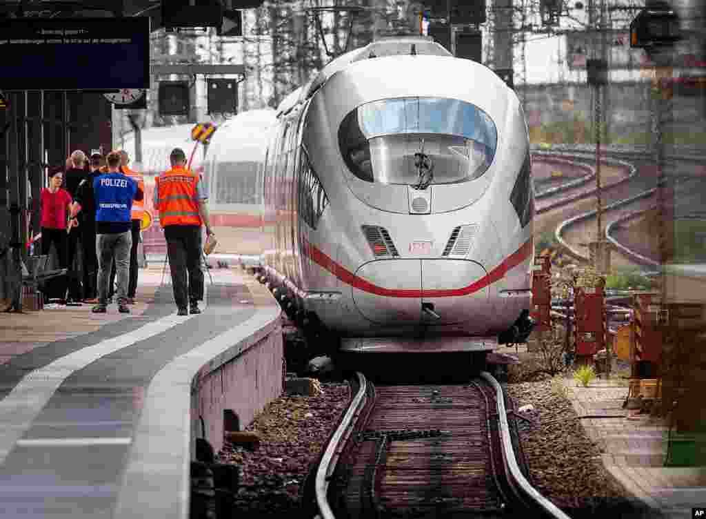 A police officer walks next to an ICE highspeed train at the main station in Frankfurt, Germany. An 8-year-old boy was run over by the train and killed after a man pushed him and his mother onto the tracks. The mother was able to escape.