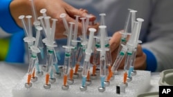 A nurse prepares vaccines in the Wizink Center, currently used for COVID-19 vaccinations in Madrid, Spain, Dec. 1, 2021.