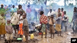 Des enfants burundais réfugiés au Rwanda se tiennent dans la boue près de leurs tentes au camp de Gashora dans le district de Bugesera, (au Rwanda), le 24 avril 2015.