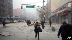 Warga berlarian karena ledakan dan gedung roboh di Harlem, New York (12/3). (AP/Jeremy Sailing)