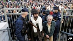 Cedric Herrou, center, a French activist farmer who faces up to five years in prison and 30,000 euros in fines as he goes on trial accused of helping African migrants cross the border from Italy, arrives at the Nice courthouse, southern France, Jan. 4, 2017.