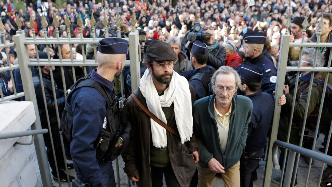 Cedric Herrou, center, a French activist farmer who faces up to five years in prison and 30,000 euros in fines as he goes on trial accused of helping African migrants cross the border from Italy, arrives at the Nice courthouse, southern France, Jan. 4, 2017.