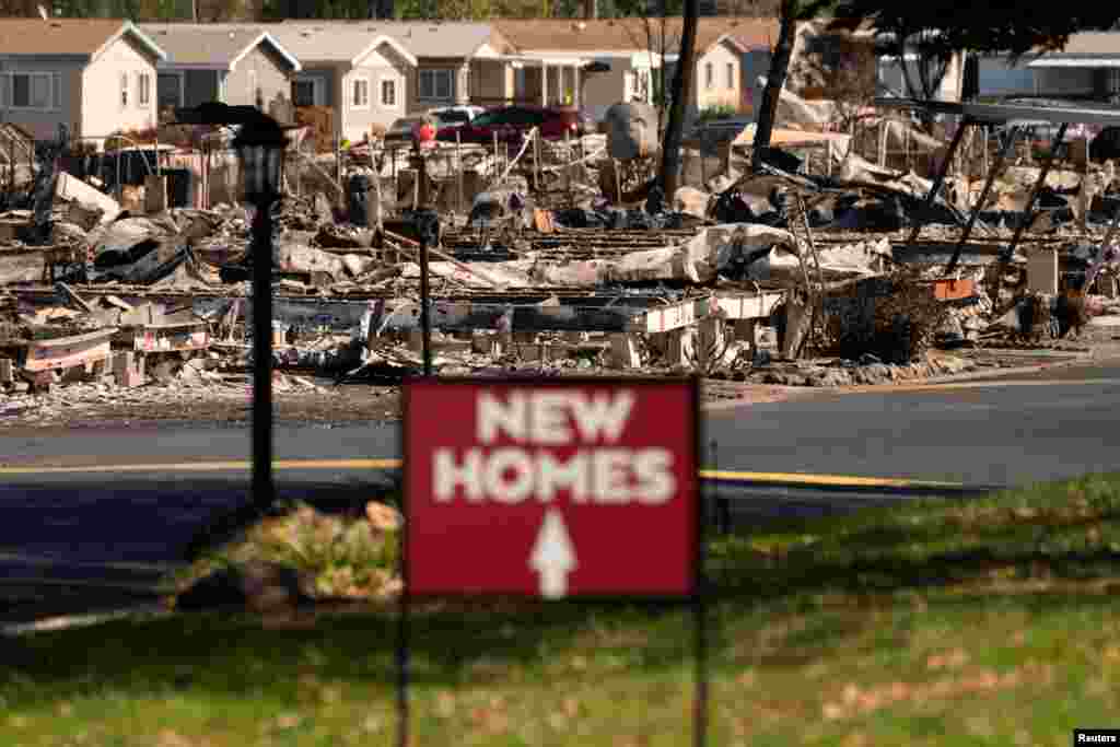 A sign advertising new homes stands in a neighborhood severely damaged by wildfire in Medford, Oregon, Sept. 20, 2020.