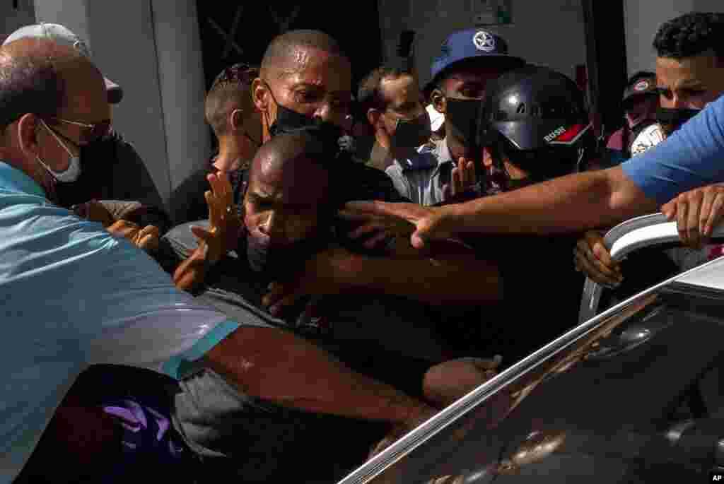 Police detain an anti-government demonstrator during a protest in Havana, Cuba, July 11, 2021.