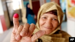 A voter displays her inked finger after she cast her ballot on constitutional amendments during the second day of three-day voting at polling station in Cairo, Egypt, April 21, 2019. 