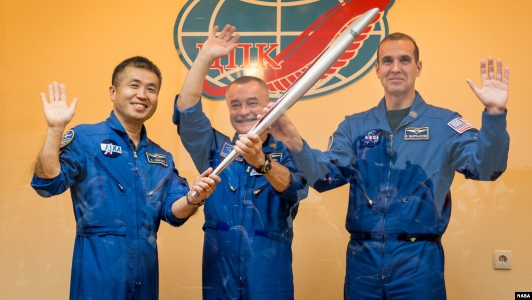 Los tripulantes de la expedición 38, el ingeniero de vuelo japonés Koichi Wakata, el comandante ruso del cohete Soyuz, Mikhail Tyurin y el ingeniero de vuelo estadounidense de la NASA Rick Mastracchio, posan con la antorcha Olímpica previo a su partida.