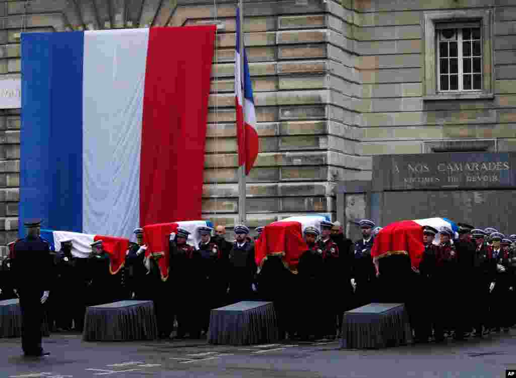Police officers carry the coffins of the four victims of last week&#39;s knife attack during a ceremony in the courtyard of the Paris police headquarters in France.