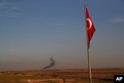 In this photo taken from the Turkish side of the border between Turkey and Syria, in Akcakale, Sanliurfa province, southeastern Turkey, smoke billows from a fire inside Syria during bombardment by Turkish forces Wednesday, Oct. 9, 2019.