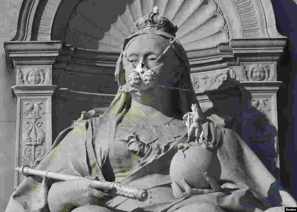 A depiction of a gas mask placed by environmental protest group Greenpeace is seen on a statue of Britain&#39;s Queen Victoria near Buckingham Palace in London, England.