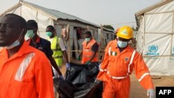 Des membres du personnel de l’Association nationale de gestion des urgences (Nema) évacuent dans un sac en plastic une victime décédée lors d’un échange de tirs entre l’armée et les islamistes de Boko Haram, Nigeria, 27 avril 2018.