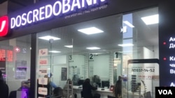 FILE - Customers do business in a branch of DosCredo Bank, a Kyrgyzstani bank in Bishkek, Nov. 19, 2024.