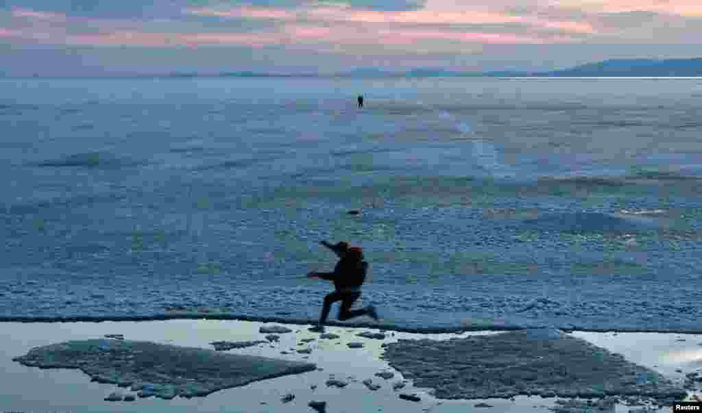 A teenager jumps from floe to floe during an ice drift in Amur Bay in the far eastern city of Vladivostok, Russia.
