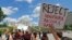 Protesters hold signs and march in front of the State Capitol across the street from the U.S. 4th Circuit Court of Appeals in Richmond, Virginia., May 8, 2017.