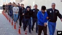 In this photo taken on April 26, 2017, Police officers escort people, arrested because of suspected links to U.S.-based cleric Fethullah Gulen, in Kayseri, Turkey. 