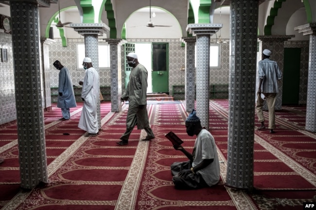 Muslim worshippers take their places whilst adhering to social distancing measures before prayer as Mosques open for the first time after two months in Dakar on May 12, 2020.