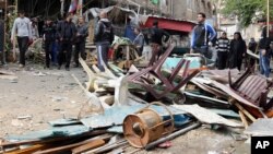 Iraqis inspect the aftermath of a late-night bombing at a cafe in Bayaa neighborhood, southwestern Baghdad, Iraq, Nov. 21, 2013.