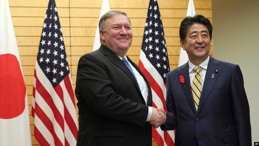 U.S. Secretary of State Mike Pompeo, left, shakes hands with Japanese Prime Minister Shinzo Abe at Abe's office in Tokyo, Oct. 6, 2018.