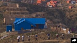 Rohingya refugee Muslims who were staying in no-man's land at Bandarban between Myanmar and Bangladesh border carry their belongings to new locations after arriving at Balukhali refugee camp, 50 kilometers (32 miles) from, Cox's Bazar, Bangladesh, Jan. 24, 2018.