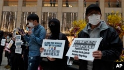 تظاهرکنندگان در هنگ کنگ با پلاکاردهایی که روی آنها نوشته: «مرزها را ببندید، به چین نه بگویید»