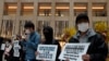 Protesters wearing masks hold placards reads" Close the border, say no to China" during a protest at a mall in Hong Kong, Tuesday, Feb. 4, 2020. Hong Kong on Tuesday reported its first death from a new virus, a man who had traveled from the mainland city…