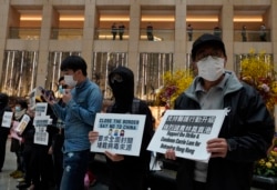 Protesters wearing masks hold placards reads" Close the border, say no to China" during a protest at a mall in Hong Kong, Tuesday, Feb. 4, 2020.