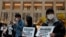Protesters wearing masks hold placards reads" Close the border, say no to China" during a protest at a mall in Hong Kong, Tuesday, Feb. 4, 2020.