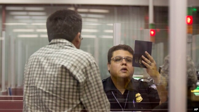 美国入境口岸的移民局官员正在查验护照。