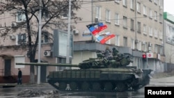 FILE - Pro-Russian separatists ride on a tank in Donetsk, eastern Ukraine, Feb. 1, 2015.