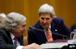 US Secretary of State John Kerry talks to US Secretary of Energy Ernest Moniz (L) during a plenary session at the United Nations building in Vienna, Austria, July 14, 2015.