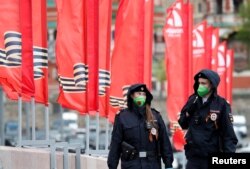 Petugas kepolisian mengenakan masker wajah berpatroli dalam hari peringatan kemenangan Rusia atas Nazi pada Perang Dunia II di tengah pandemi virus corona, di Moskow, Rusia, 9 Mei 2020. (Foto: Reuters)