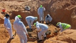 FILE - Members of the Government of National Accord's missing persons bureau exhume bodies in what Libya's internationally recognized government officials say is a mass grave, in Tarhouna city, Libya, October 27, 2020.