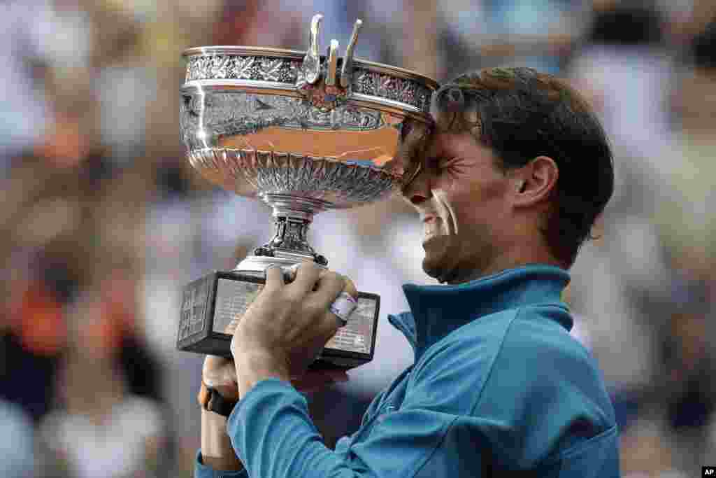 Spain&#39;s Rafael Nadal holds the trophy as he celebrates winning the men&#39;s final match of the French Open tennis tournament against Austria&#39;s Dominic Thiem in three sets 6-4, 6-3, 6-2, at the Roland Garros stadium in Paris, France.