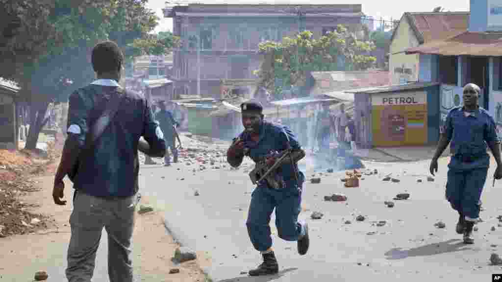 Des polciers tentent de disperser une foule d&#39;habitants en colère après que les parents d&#39;un homme tué par la police, ont été empêchés de l&#39;enterrer conformément à ses croyances musulmanes à Buyenzi, dans la capitale Bujumbura, Burundi mercredi 10 juin 2015