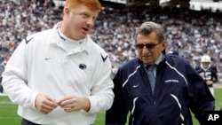 FILE - Penn State coach Joe Paterno, right, and assistant coach Mike McQueary walk off the field together before an NCAA college football game in State College, Pa., Oct. 10, 2009.
