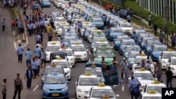 Taxis are lined up during a protest against competition from ride-hailing apps such as Uber and Grab at the main business district in Jakarta, Indonesia, March 22, 2016. 