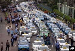 Taxis are lined up during a protest against competition from ride-hailing apps such as Uber and Grab at the main business district in Jakarta, Indonesia, March 22, 2016.