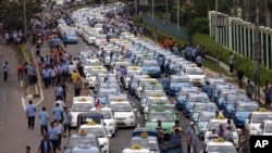 FILE - Taxis are lined up during a protest against competition from ride-hailing apps such as Uber and Grab at the main business district in Jakarta, Indonesia, March 22, 2016. 