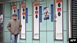 FILE - A man walks past public toilets in Shanghai during the World Toilet Day, Nov. 19, 2009.