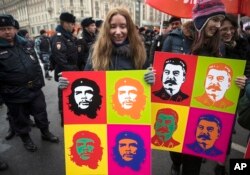 Communist party supporters carry Andy Warhol-style portraits of Cuban Revolution hero Ernesto 'Che' Guevara, center, and Soviet leader Josef Stalin, right, during a demonstration marking the 100th anniversary of the 1917 Bolshevik revolution in Moscow, Nov. 7, 2017.